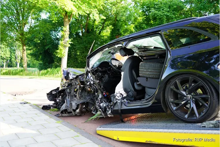 Auto total loss na botsing tegen boom, bestuurder zit bekneld