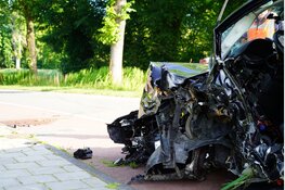 Auto total loss na botsing tegen boom, bestuurder zit bekneld
