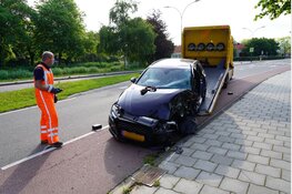 Auto total loss na botsing tegen boom, bestuurder zit bekneld