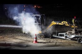 Graafmachine in brand langs dijk in Oosthuizen
