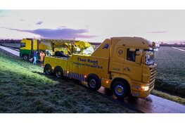 Vrachtwagen op omvallen op spekgladde dijk in Schardam