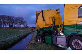 Vrachtwagen op omvallen op spekgladde dijk in Schardam